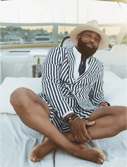 Man in a striped suit and hat relaxing on a yacht